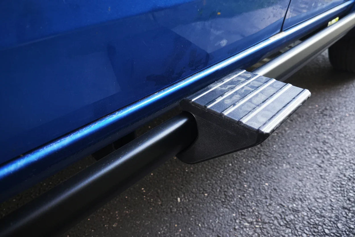 Close-up of snap-on step attachment on blue truck sidestep, outdoor setting
