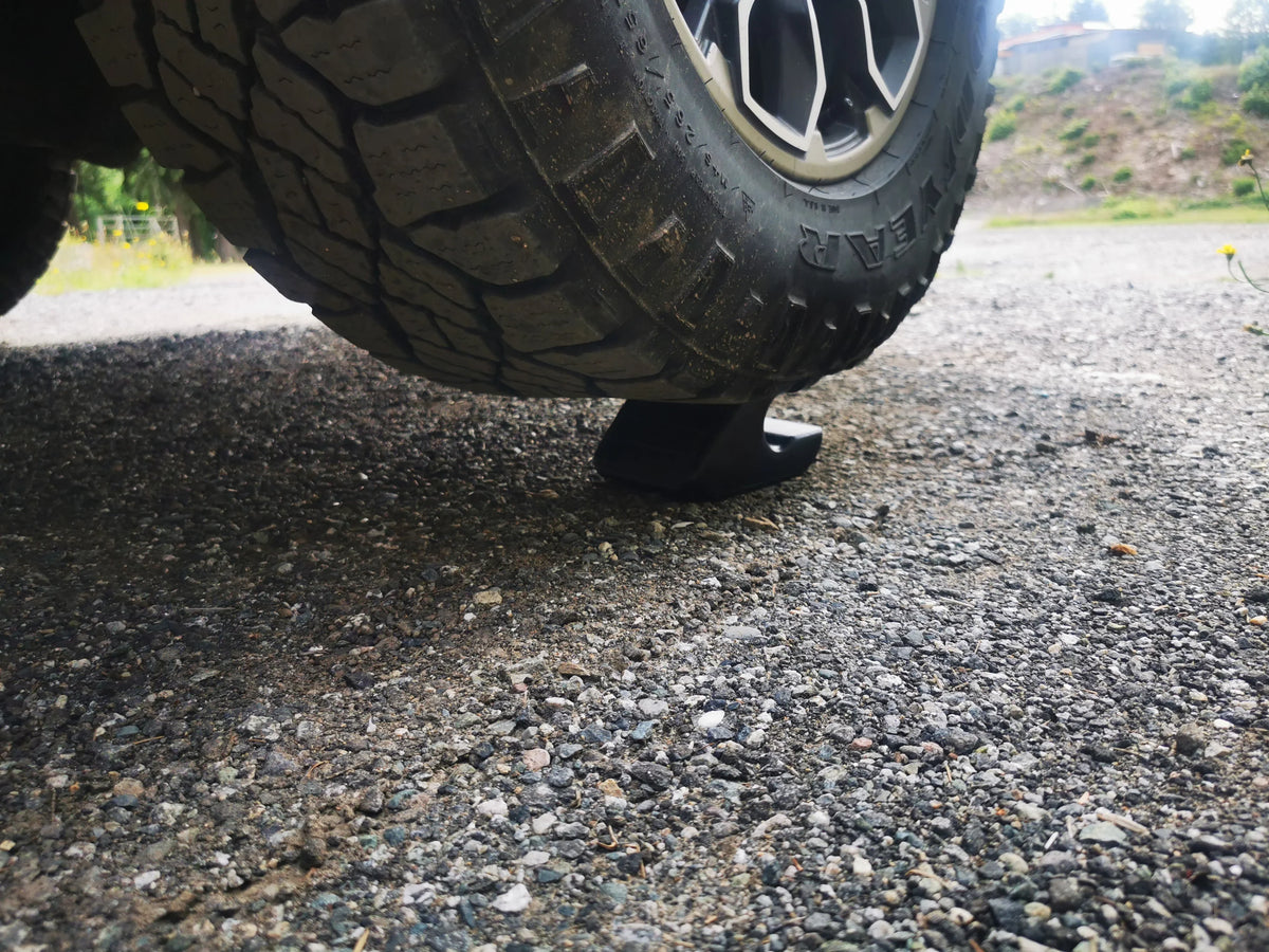 Close-up of off-road truck tire on gravel with a black 3D-printed support accessory